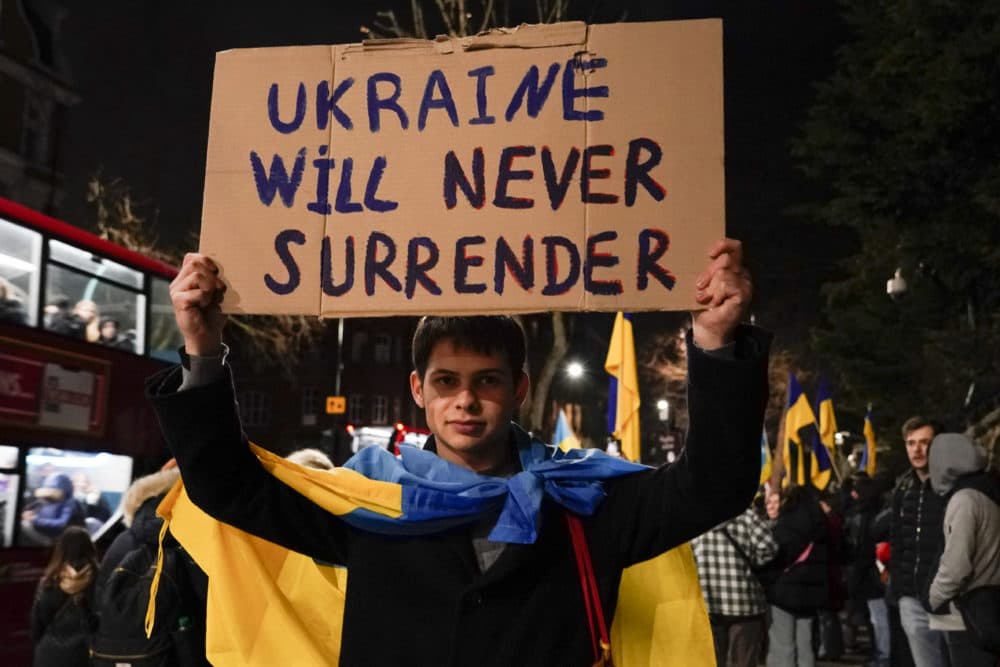 A demonstrator holds a placard as he attends a protest outside the Russian Embassy, in London, Wednesday, Feb. 23, 2022. (Alberto Pezzali/AP)