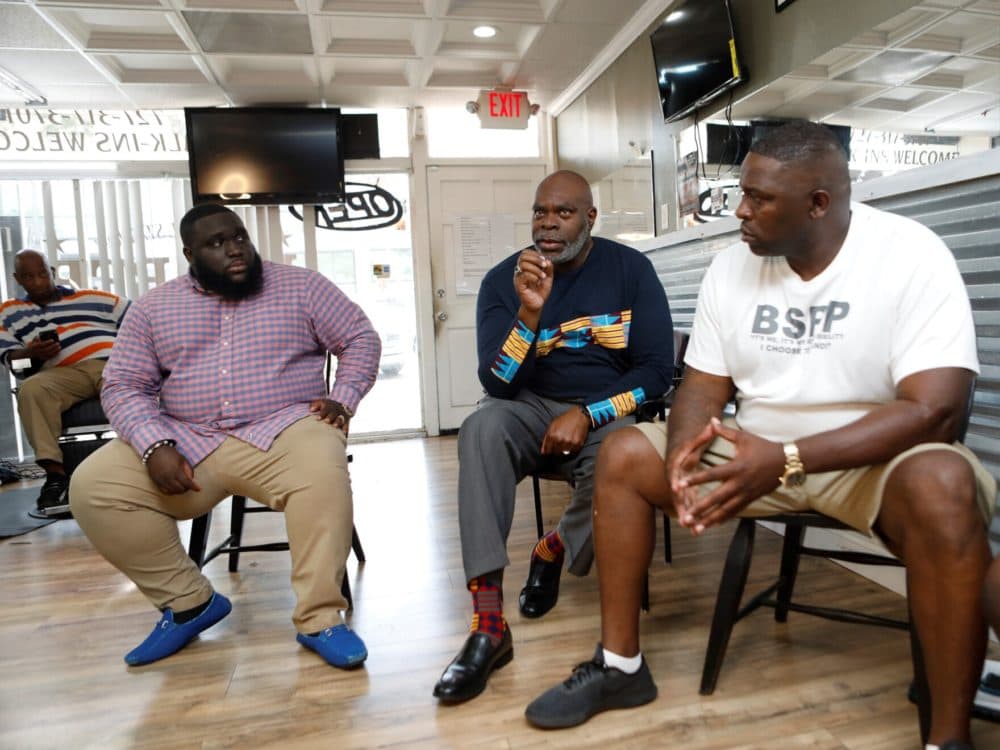 S. Kent Butler (center), president of the American Counseling Association, led a group of men in a conversation about mental health at a barbershop in St. Petersburg, part of the recent Healing While Black summit. (Octavio Jones/WUSF Public Media)