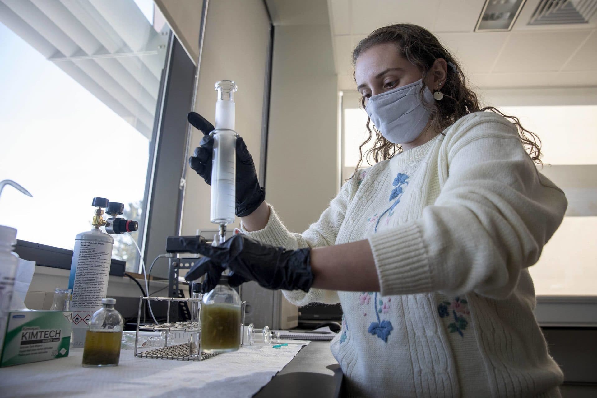Gabriella Lacono, technicienne de recherche, montre comment retirer un échantillon de gaz d'une bouteille de test.  (Robin Lubbock/WBUR)