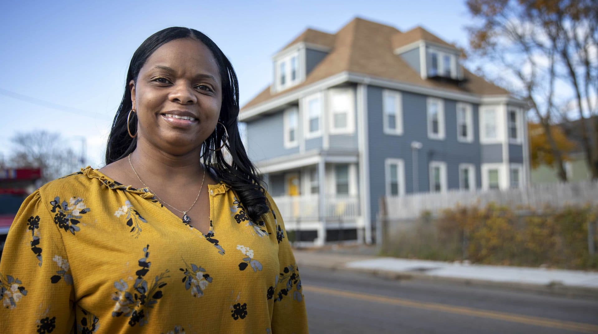 Cecilia Dixon stands on Harvard Street in Dorchester near her new home. (Robin Lubbock/WBUR)