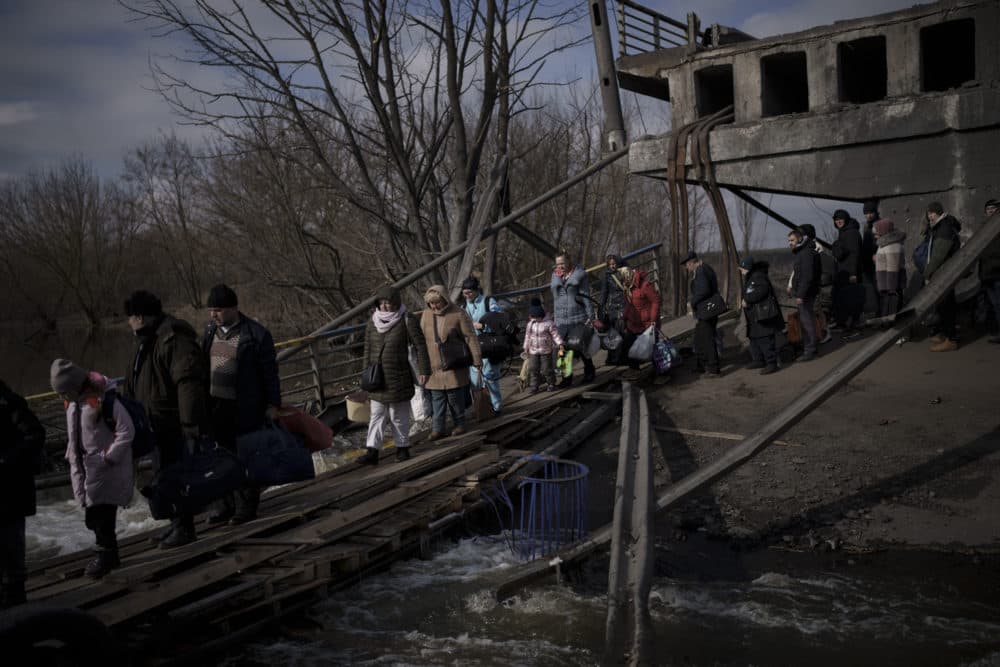 Ukrainians cross an improvised path under a destroyed bridge while fleeing Irpin, on the outskirts of Kyiv, Ukraine, March 9, 2022. (Felipe Dana/AP)