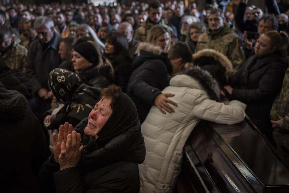 Relatives and friends attend a funeral ceremony for four of the Ukrainian military servicemen, who were killed during an airstrike in a military base in Yarokiv, in a church in Lviv, Ukraine, Tuesday, March 15, 2022. At least 35 people were killed and many wounded in Sunday's Russian missile strike on a military training base near Ukraine's western border with NATO member Poland. (AP Photo/Bernat Armangue)