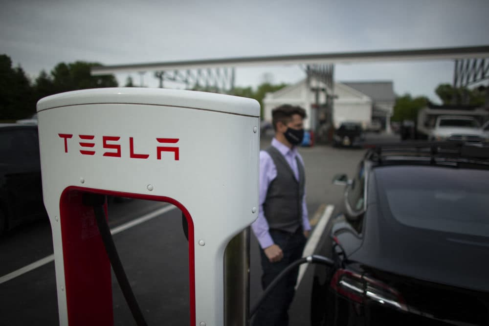 Ben Rich charges his Tesla vehicle at a super charging station in New Jersey. (KENA BETANCUR/AFP via Getty Images)