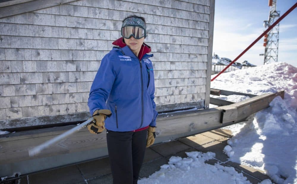 Ant observatorijos stogo orų stebėtoja Jackie Bellefontaine sukasi psichrometrą santykinei oro drėgmei matuoti.  (Robinas Lubbockas / WBUR)
