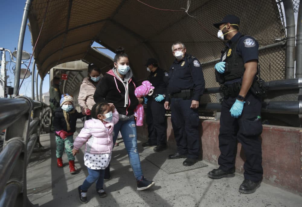  In this Friday, Feb. 26, 2021 file photo, a migrant family wearing face masks crosses the border into El Paso, Texas, in Ciudad Juarez, Mexico. (AP Photo/Christian Chavez)