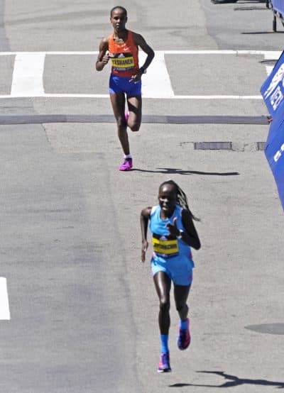 Ababel Yeshaneh, of Ethiopia, top, tries to keep pace but is outrun by Peres Jepchirchir, of Kenya, bottom, as they approach the finish line of the Boston Marathon. (AP Photo/Charles Krupa)