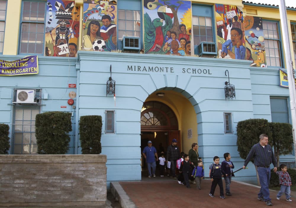 Students are escorted to a waiting bus as they leave Miramonte Elementary school in Los Angeles after classes. (Damian Dovarganes/AP)
