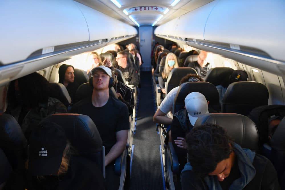 Airline passengers, some not wearing face masks following the end of COVID-19 public transportation rules, sit during a American Airlines flight operated by SkyWest Airlines from Los Angeles International Airport (LAX) in California to Denver, Colorado on April 19, 2022. (Patrick T. Fallon/AFP via Getty Images)