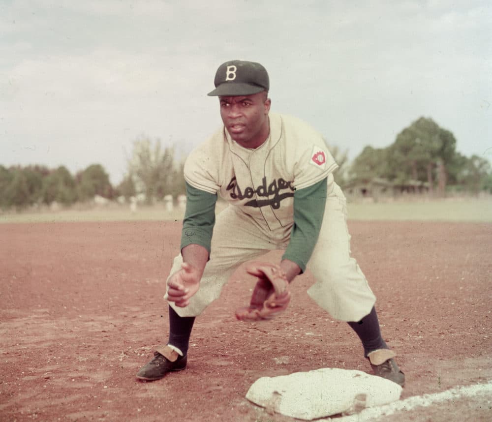 American professional baseball player Jackie Robinson (1919 - 1972) of the Brooklyn Dodgers, dressed in a road uniform, crouches by the base and prepares to catch a ball, 1951. Throughout the course of his baseball career Robinson played several positions on the infield as well as serving as outfielder. (Photo by Keystone/Getty Images)
