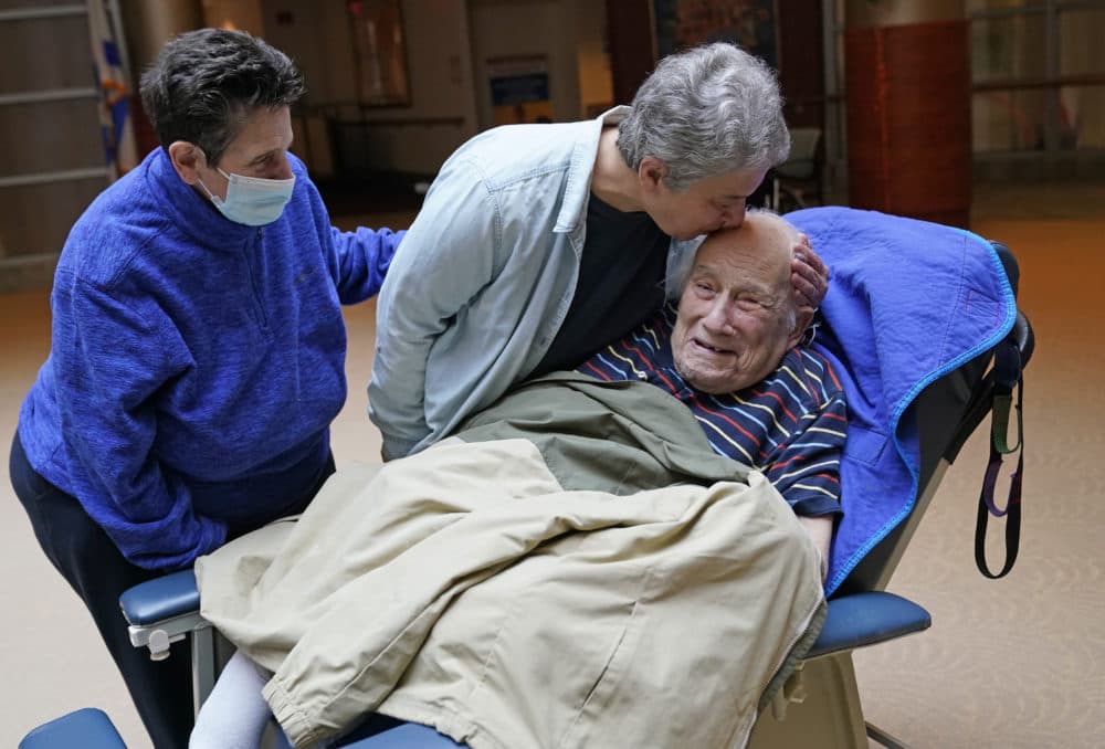 Melvin Goldstein, 90, smiles as his daughter Barbara Goldstein gives him a kiss on the head during their first in-person, indoor family visit inside the Hebrew Home at Riverdale, March 28, 2021, in the Bronx borough of New York. (Kathy Willens/AP)
