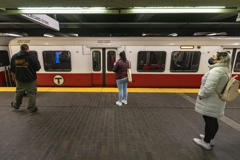 Commuters wait as a Red Line train pulls into Park Street Station. (Jesse Costa/WBUR)