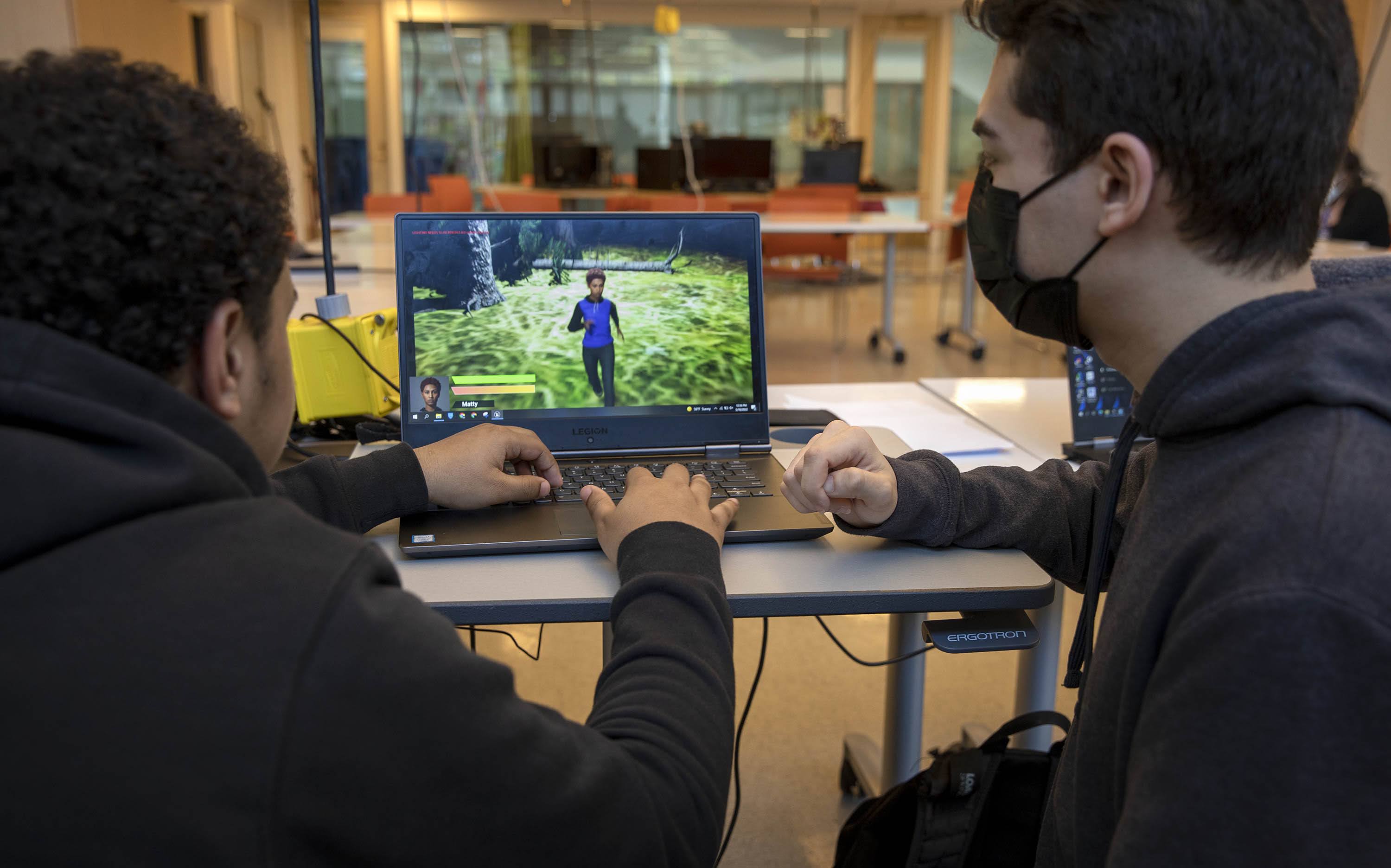 Edson Miranda and JR Murillo demonstrate a video game they designed. (Robin Lubbock/WBUR)