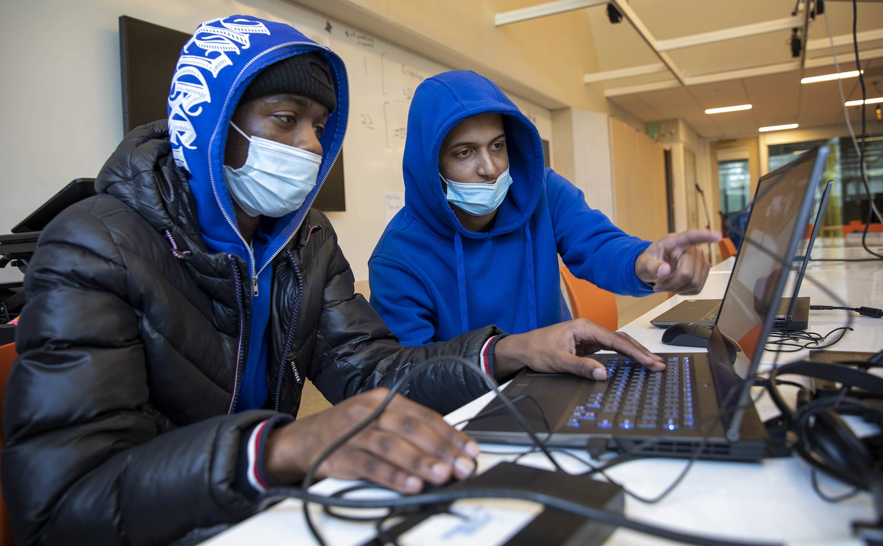 Miguel Tavares and Sidonio Lopes play "5V5," a game they created in their computer science class at Dearborn STEM Academy in Roxbury. (Robin Lubbock/WBUR)