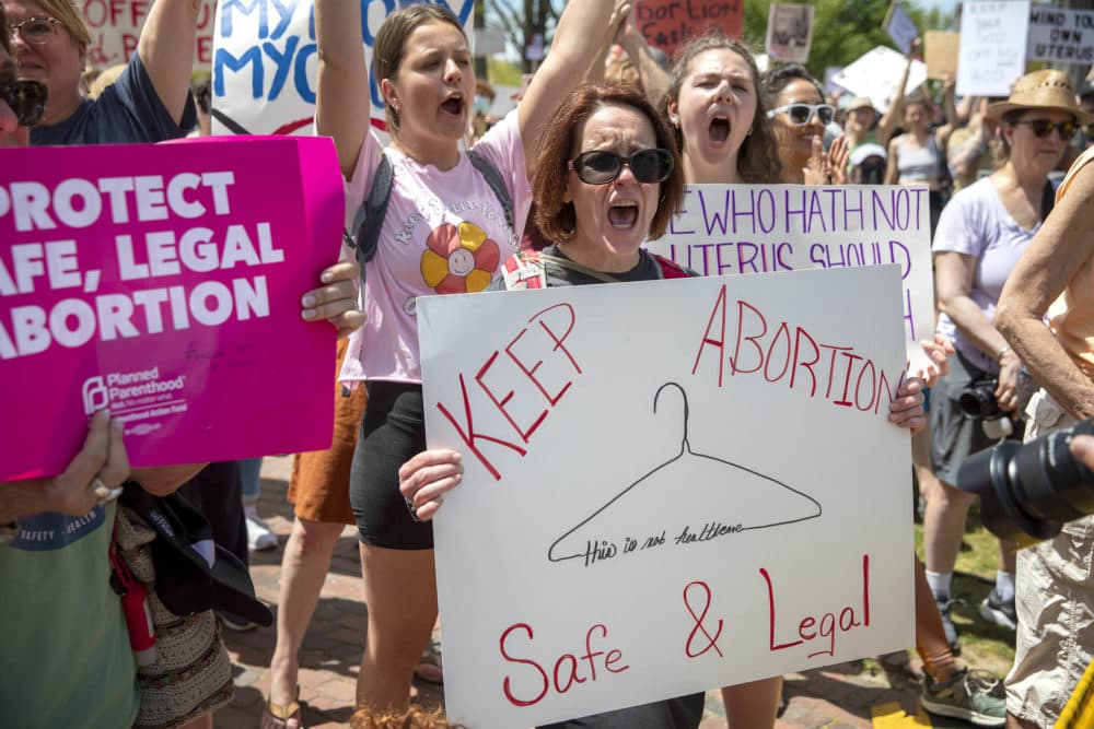 A protester holds up a "Keep Abortion Safe & Legal" sign at the Bans Off Our Bodies rally on Boston Common. (Robin Lubbock/WBUR)