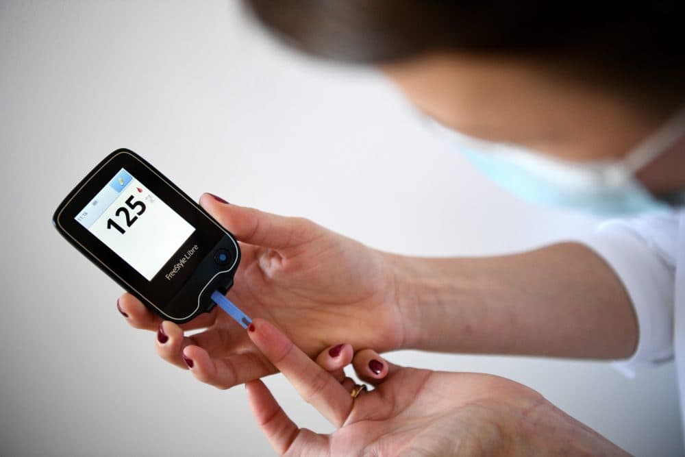 A woman with diabetes uses a glucometer to measure the glycemia in her blood in Paris on March 24, 2020. (Franck Fife/AFP via Getty Images)