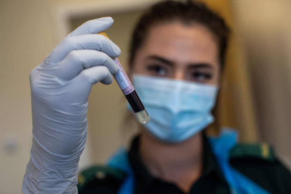 A paramedic holds a blood sample. (Simon Dawson - Pool/Getty Images)