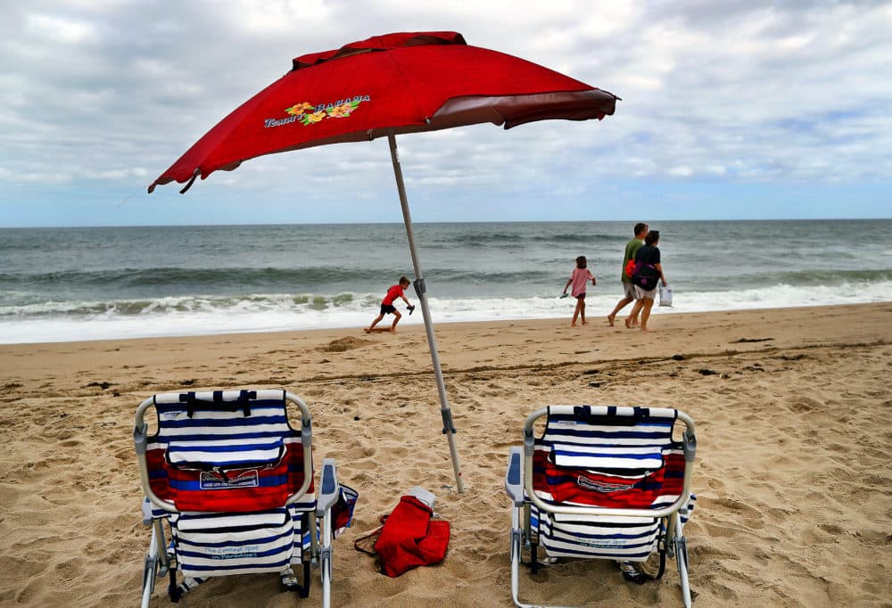 Eastham, MA - September 21: On September 21, 2021, it was the last day of summer as people enjoyed Nauset Light Beach in Eastham, MA, where the summer crowds have left for the season. A family walks past an umbrella planted on the beach. (Photo by John Tlumacki/The Boston Globe via Getty Images)
