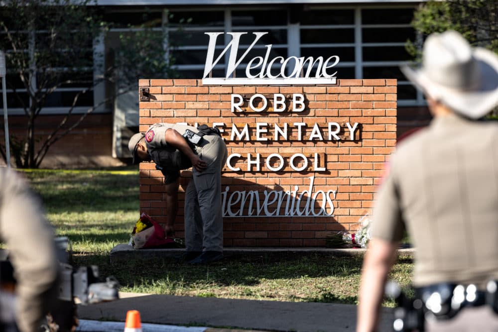 A Texas State Trooper places flowers for the victims of a mass shooting at Robb Elementary School Tuesady in Uvalde, Texas. (Jordan Vonderhaar/Getty Images)