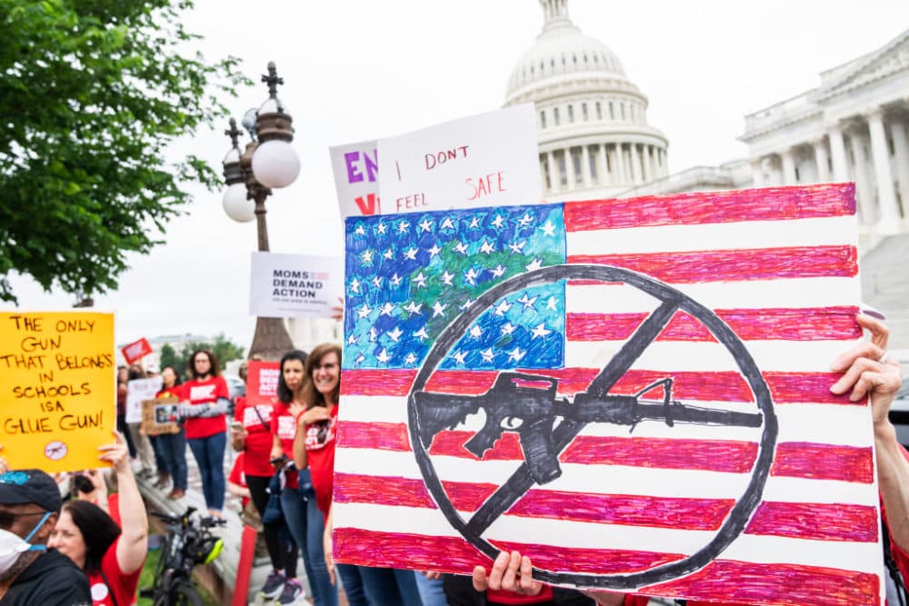Demonstrators hold signs during a rally with senators outside the U.S. Capitol to demand the Senate take action on gun safety on Thursday, May 26, 2022, in the wake of the Robb Elementary School shooting in Texas. (Tom Williams/CQ-Roll Call, Inc via Getty Images)
