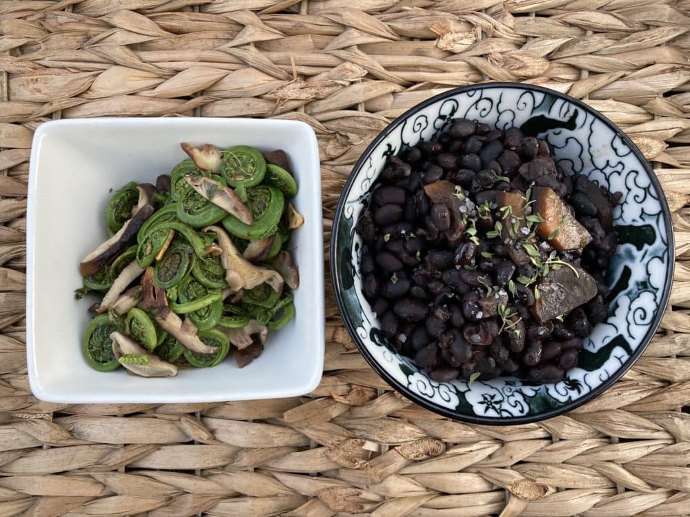 One of Andrea's favorite meals: Sauteed fiddleheads, shiitake mushrooms and garlic (left). Pressure-cooked black beans with carrots, garlic, onion and mint thyme (right). (Andrea Shea/WBUR)