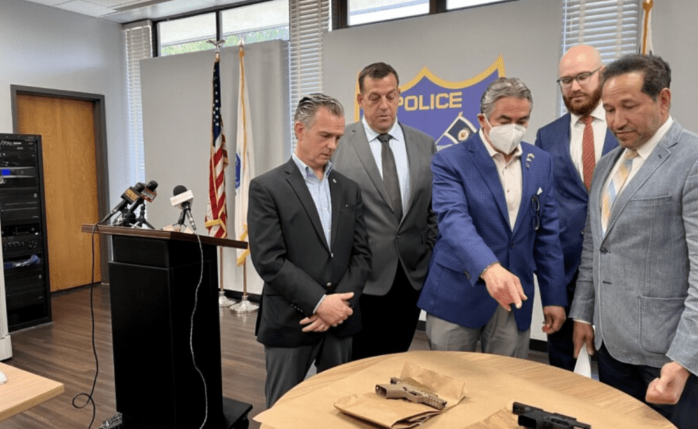 State Rep. Brian Ashe, Springfield Deputy Chief of Police Steve Kent, Mayor Domenic Sarno, Kendall Jacobsen, associate regional director of government affairs with Everytown for Gun Safety, and state Rep. Carlos Gonzalez look at parts of ghost guns. (Nirvani Williams/NEPM)