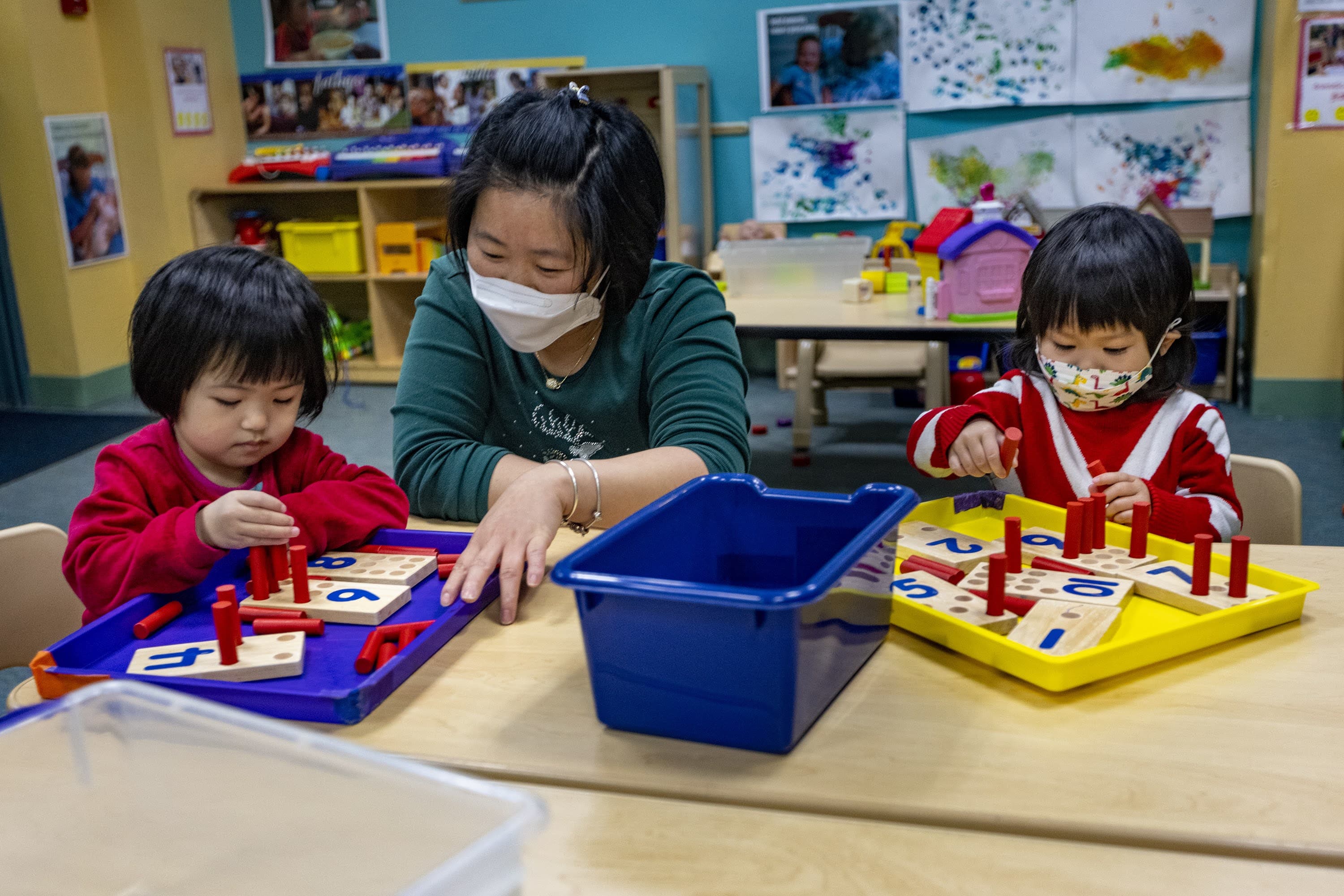 Teacher Mandy He works on counting with students at the Acorn Center for Early Education & Care at the Boston Chinatown Neighborhood Center. (Jesse Costa/WBUR)