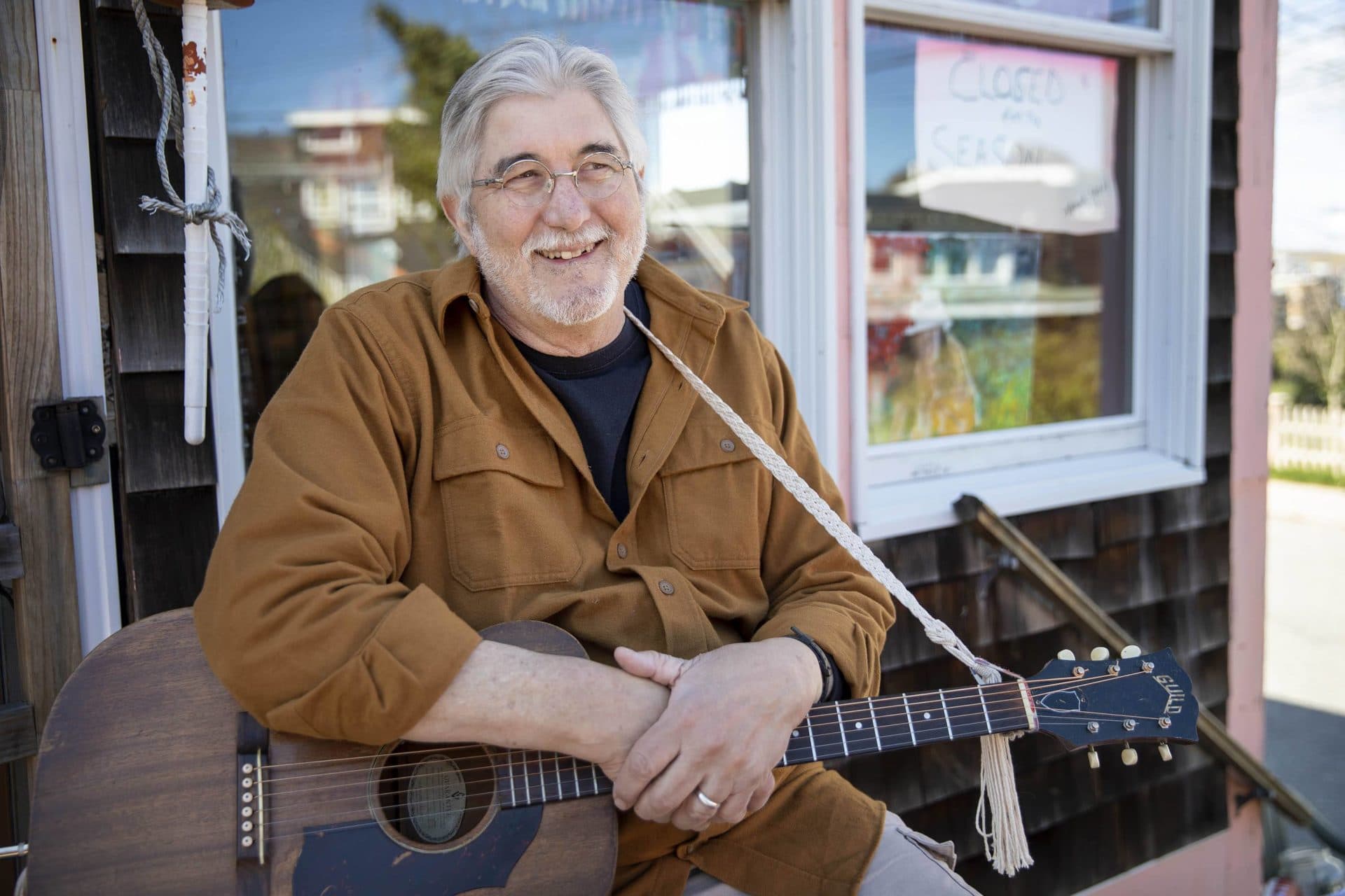 Kitt Cox takes a break between songs at a "Busking for Babies" event in Gloucester, where funds are donated to purchase diapers for families that need them. (Robin Lubbock/WBUR)