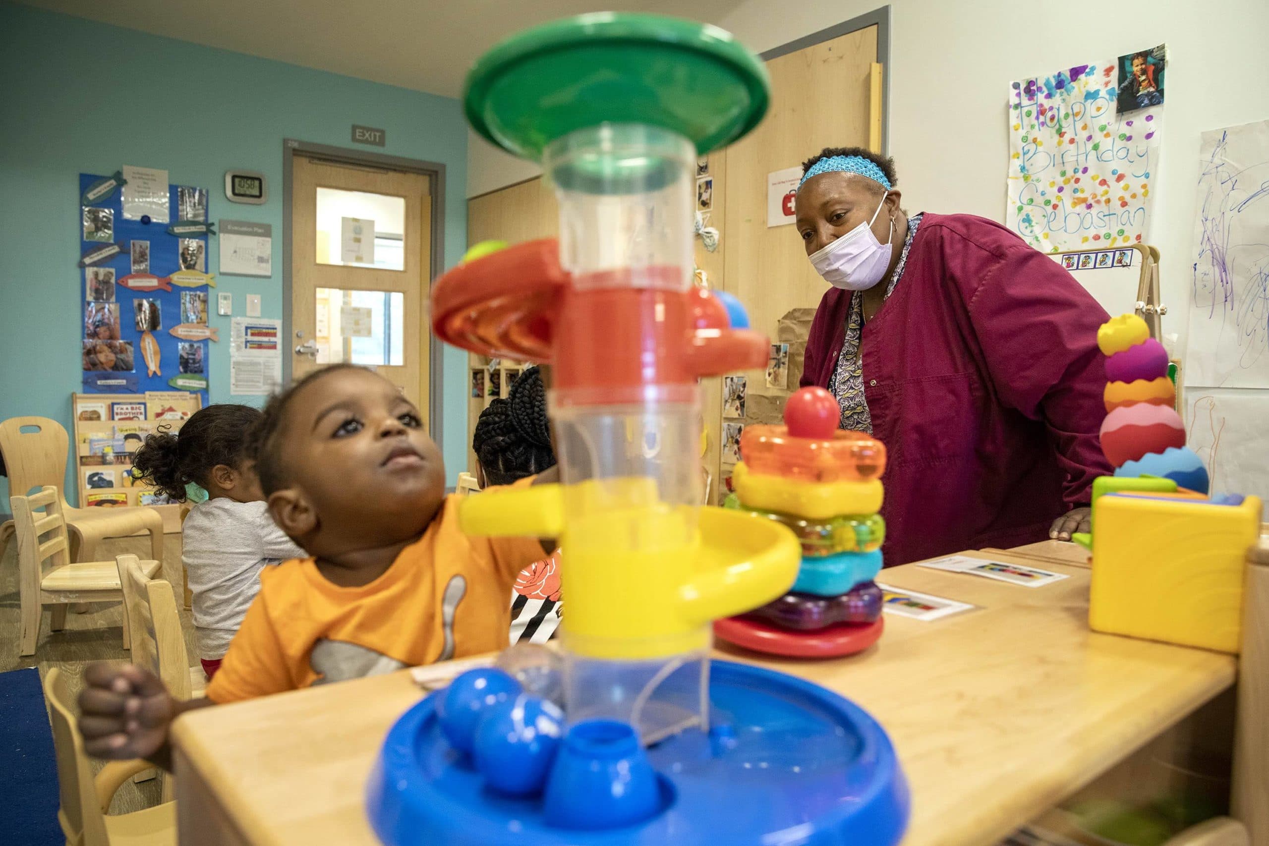 Deneen Coren watches as a child in her class at Horizons for Homeless Children rolls a ball down a slide.  (Robin Lubbock/WBUR)