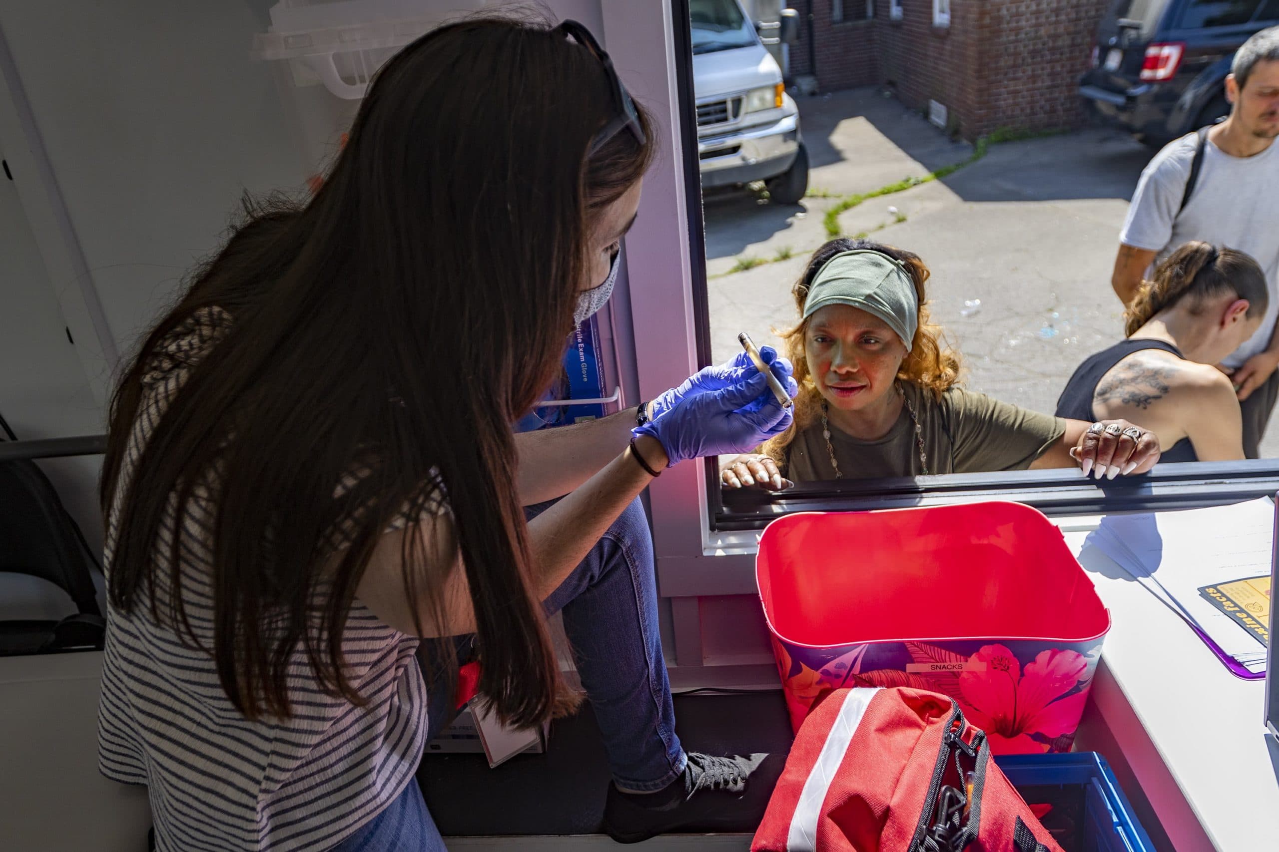 Michelle returns a used pipe to Kelly Celata, who manages the mobile addiction outreach trailer for the Brockton Neighborhood Health Center. (Jesse Costa/WBUR)