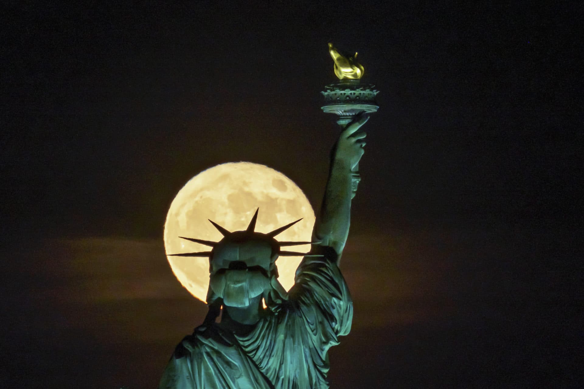 La super lune fraise se lève devant la Statue de la Liberté à New York.  (J.David Ake/AP)