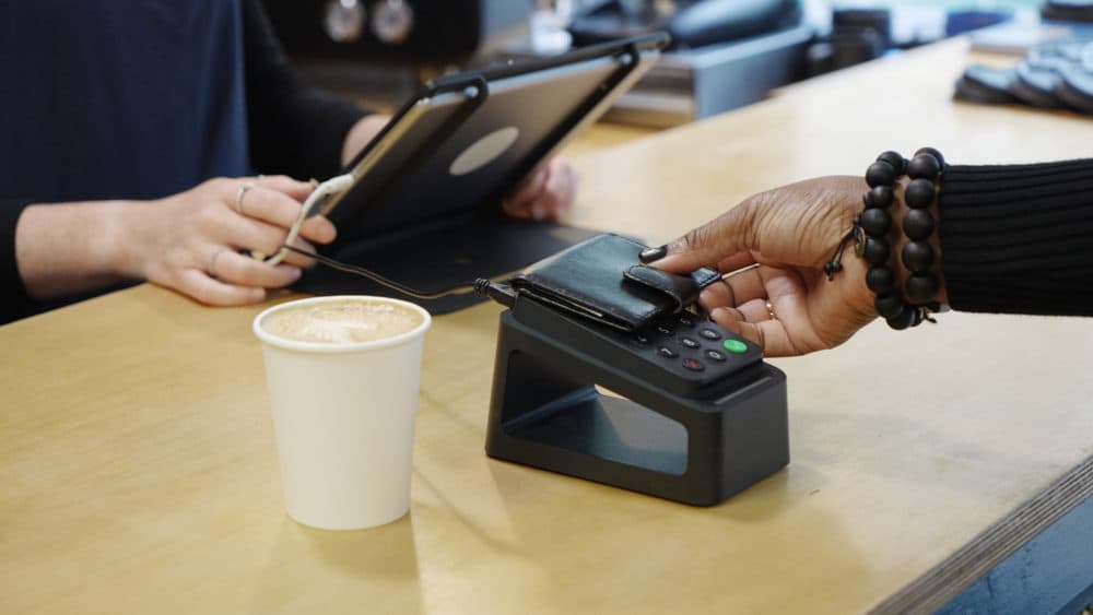 A customer makes a contactless payment at a coffee shop. (Tara Moore/Getty Images)