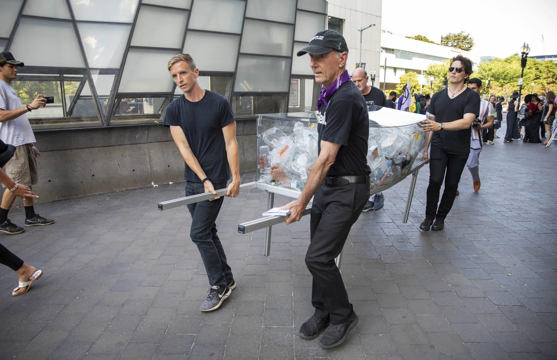 L'équipe de l'artiste Anne-Katrin Spiess se promène "Mort du plastique"  cercueil à l'entrée de la Gare du Midi.  (Robin Lubbock/WBUR)