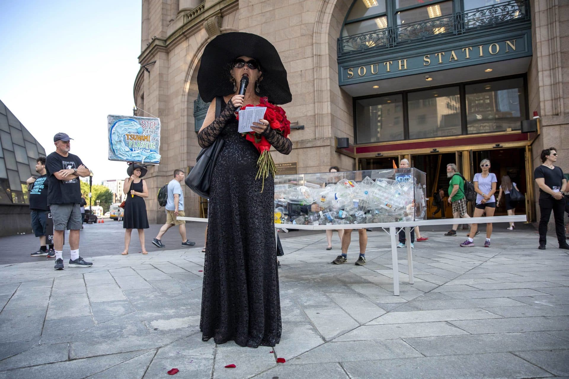 L'artiste Anne-Katrin Spiess lit un éloge funèbre lors de la représentation "Mort par le plastique"  à l'entrée de la Gare du Midi.  (Robin Lubbock/WBUR)